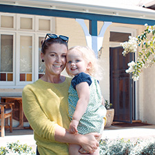 Mother and daughter outside house