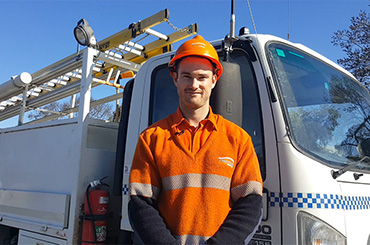Powerline worker standing in front of truck