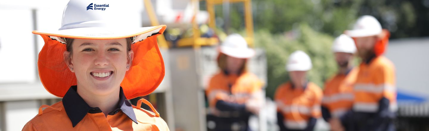 Worker looking forward with four others standing in the distance