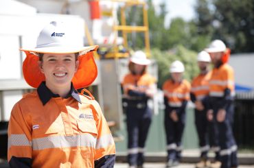 Worker looking forward with four others standing in the distance