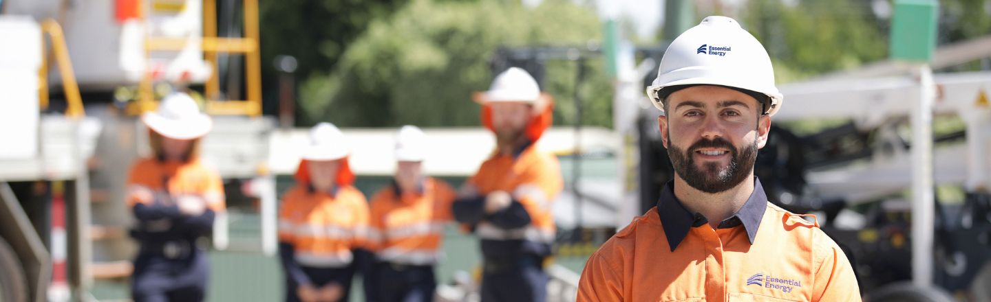 Worker at the front looking at camera with four others blurred in the background