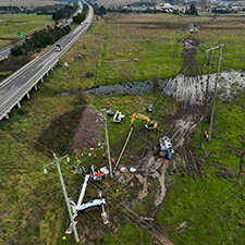 Workers changing a pole near a highway