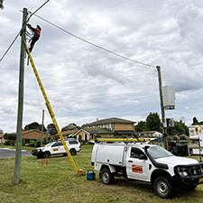 crews installing a pole-mounted battery