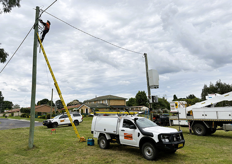 crews installing a pole-mounted battery