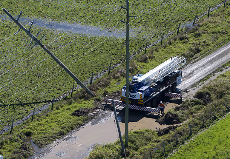 Broken pole with truck and worker nearby