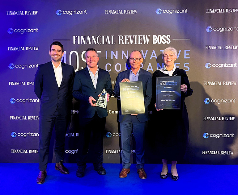 Four people smiling holding awards