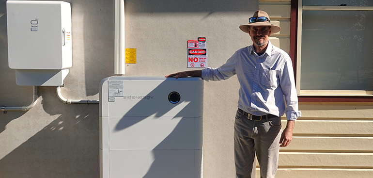 Man standing next to a battery