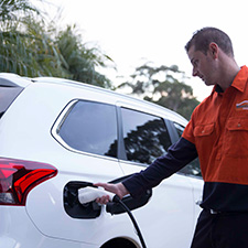Employee charging an electric vehicle