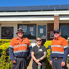 Three people standing in front of a building
