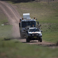 Two trucks going down a road