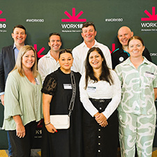 Eight people standing in front of a banner