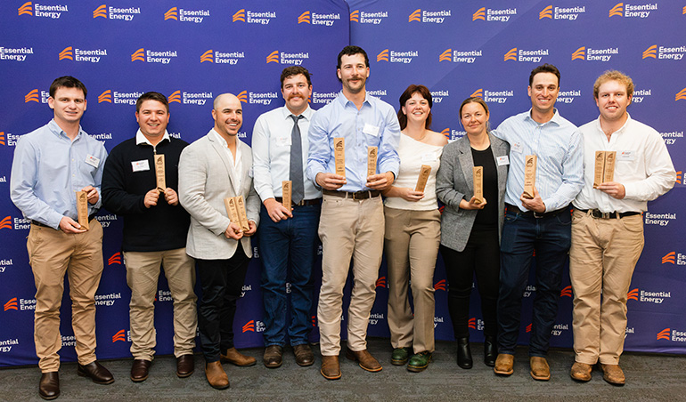 Graduates standing with their awards
