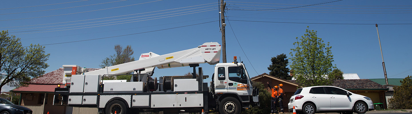 Truck and workers investigating power pole