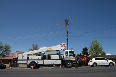 Truck and workers investigating power pole