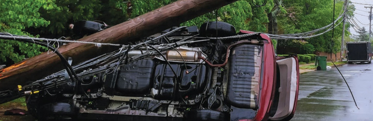 A car on its side after hitting a power pole