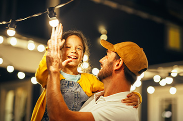 A father and daughter with lights in the background