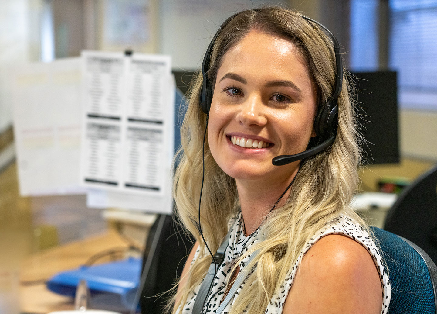 A customer support representative smiling at the camera