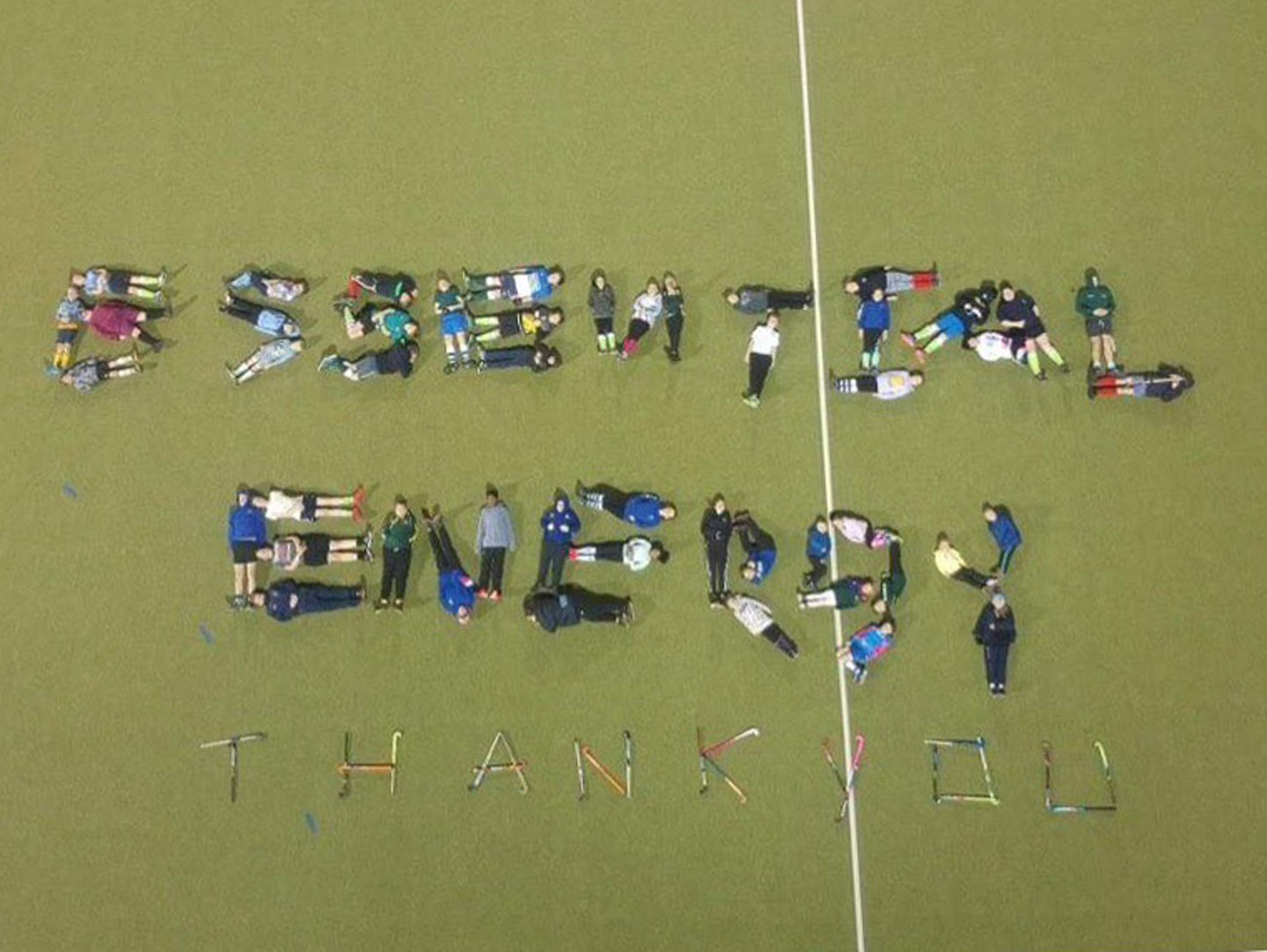 Aerial view of a group of Bathurst Junior Mens Hockey Team lying down on the ground to form a thank you message